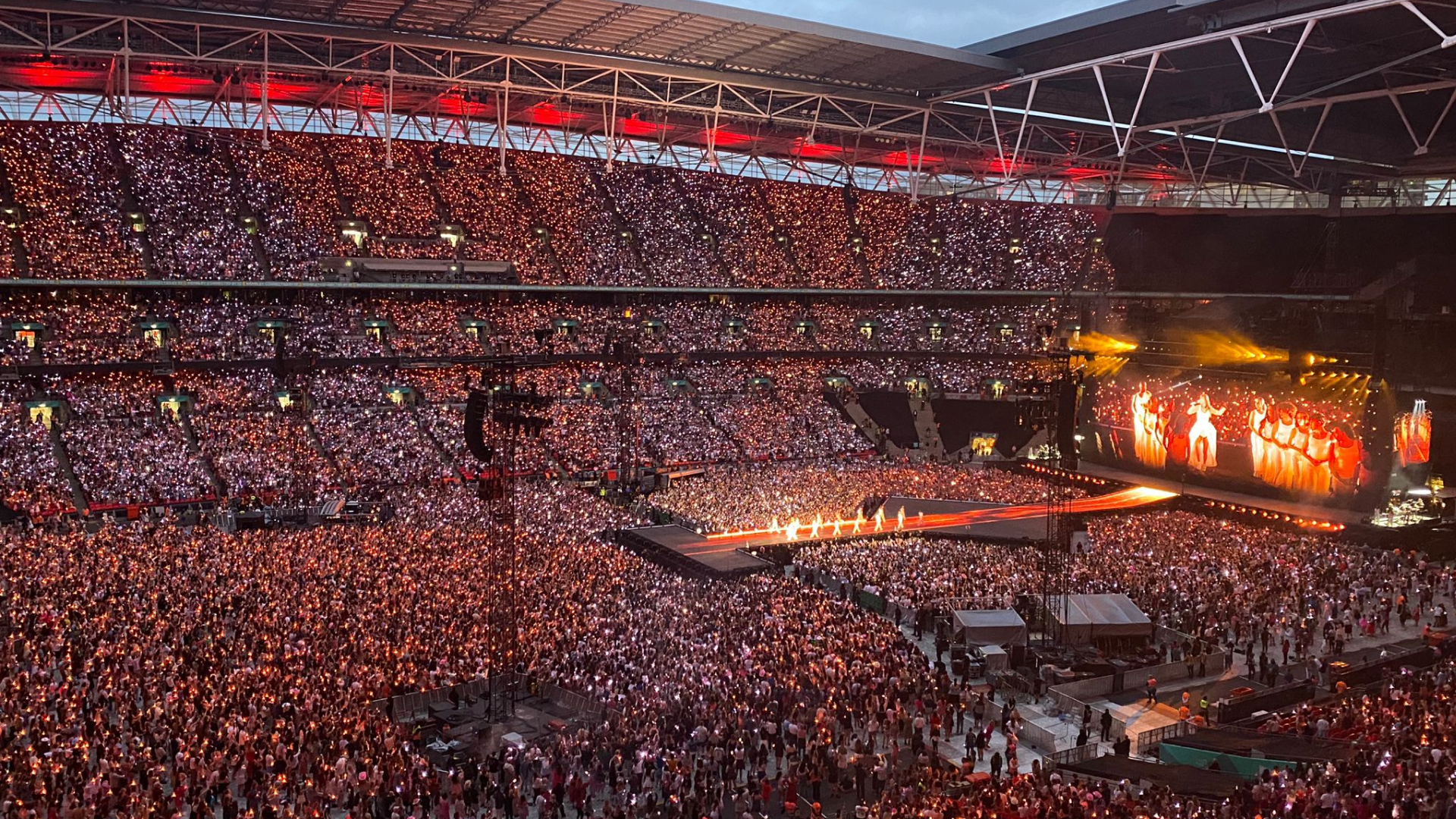 Taylor Swift performing on stage at Wembley Stadium in front of 90,000 fans.